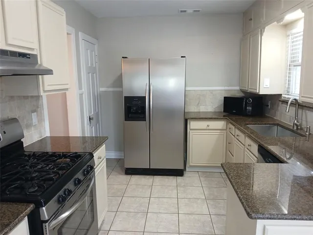 a kitchen with a stove a sink and a refrigerator