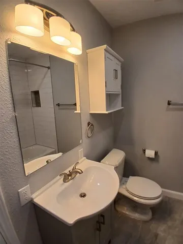 a bathroom with a sink mirror and toilet
