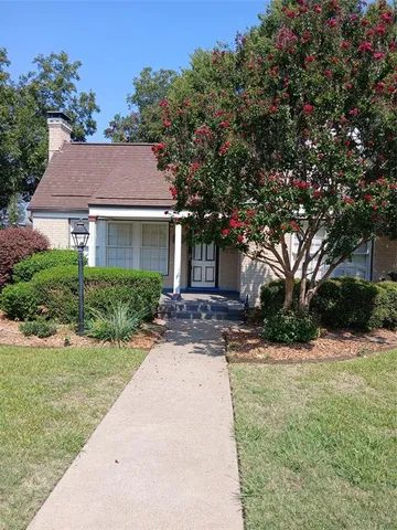 a front view of a house with a yard and potted plants