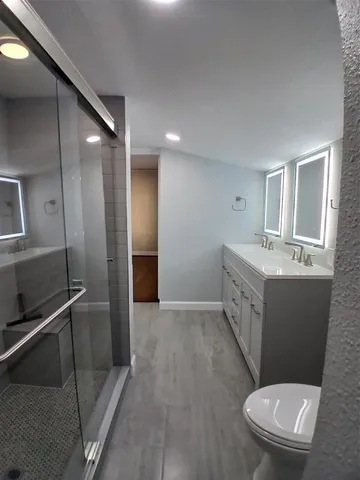 a bathroom with a sink a toilet and shower