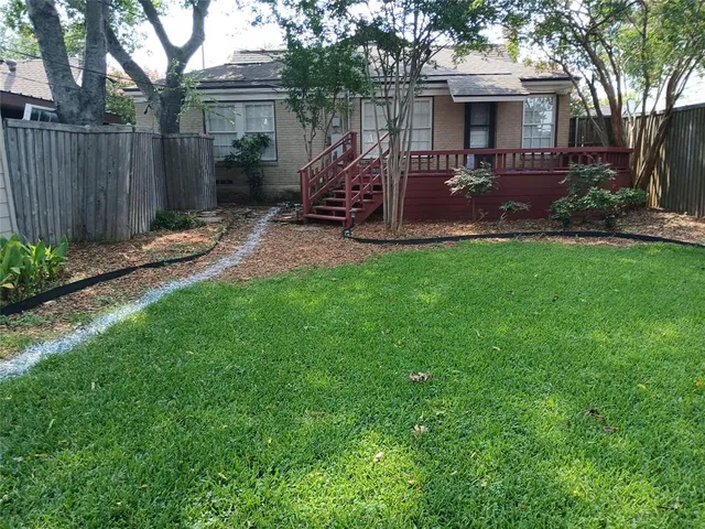 a view of a house with backyard and a tree