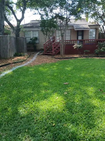 a view of a house with backyard and a tree