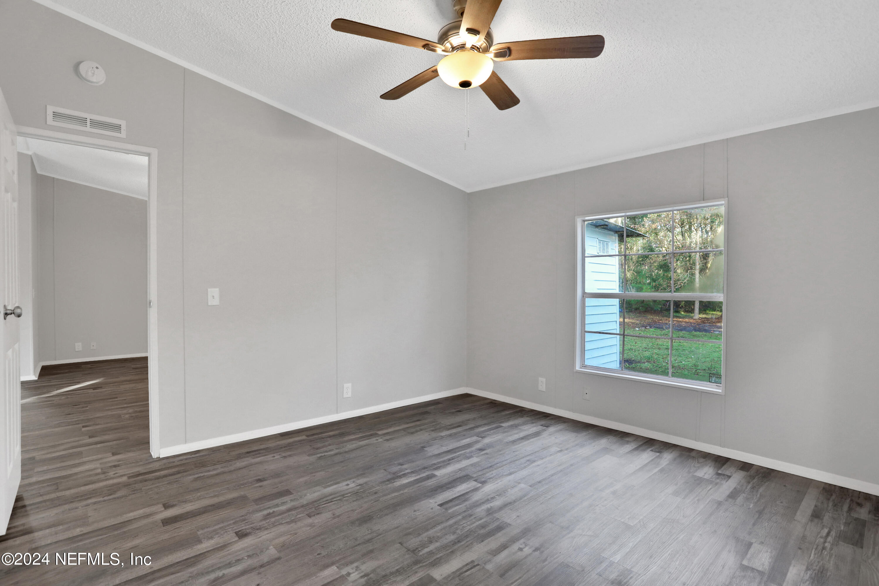 54337 Pelican Road Callahan, FL 32011 - Photo 14 of 32 wooden floor in an empty room with a window