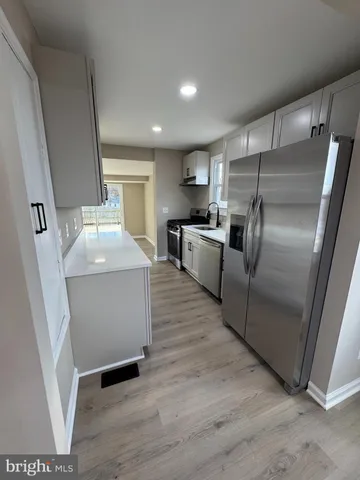 a kitchen with granite countertop a refrigerator and a sink
