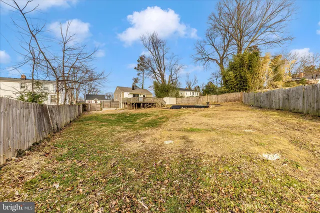 a view of a yard with wooden fence