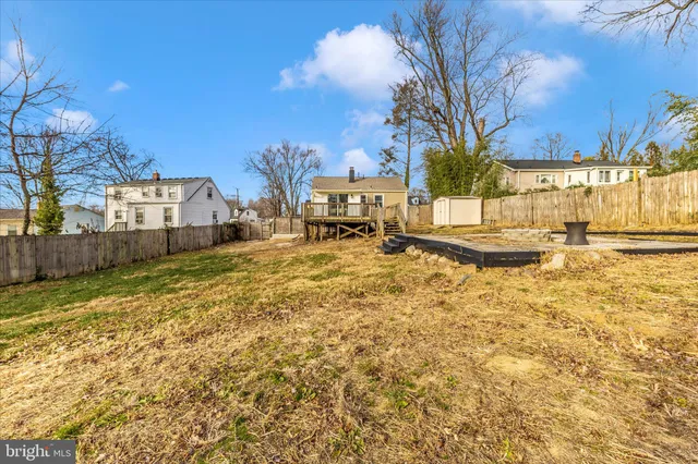 a view of a yard with wooden fence