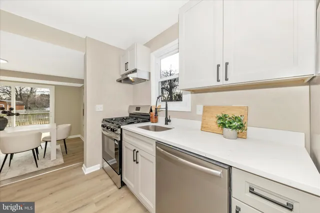 a kitchen with a sink a stove and chairs