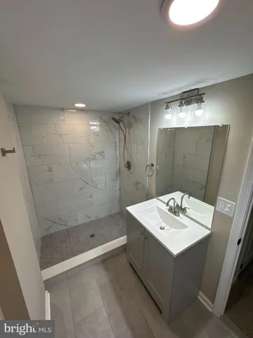 a bathroom with a sink a shower and a mirror