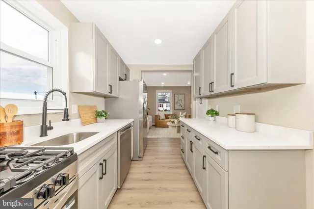 a kitchen with kitchen island a sink stove top oven and cabinets