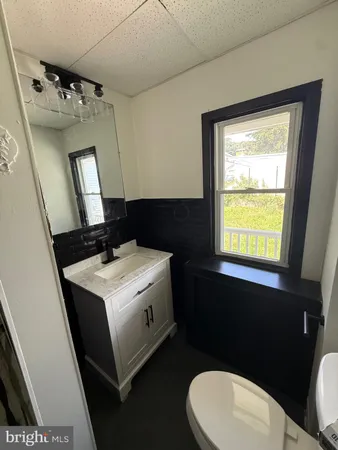 a bathroom with a sink vanity mirror and toilet