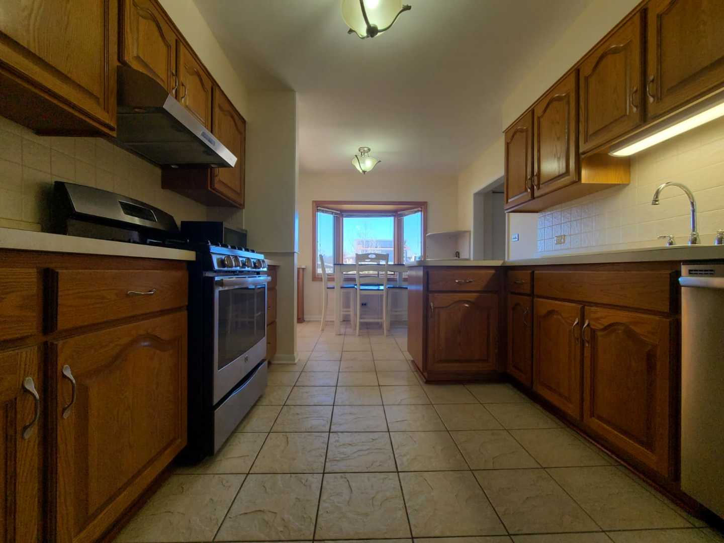 1441 Maple Street Glenview, IL 60025 - Photo 9 of 22 a kitchen with stainless steel appliances granite countertop a stove a sink and a microwave
