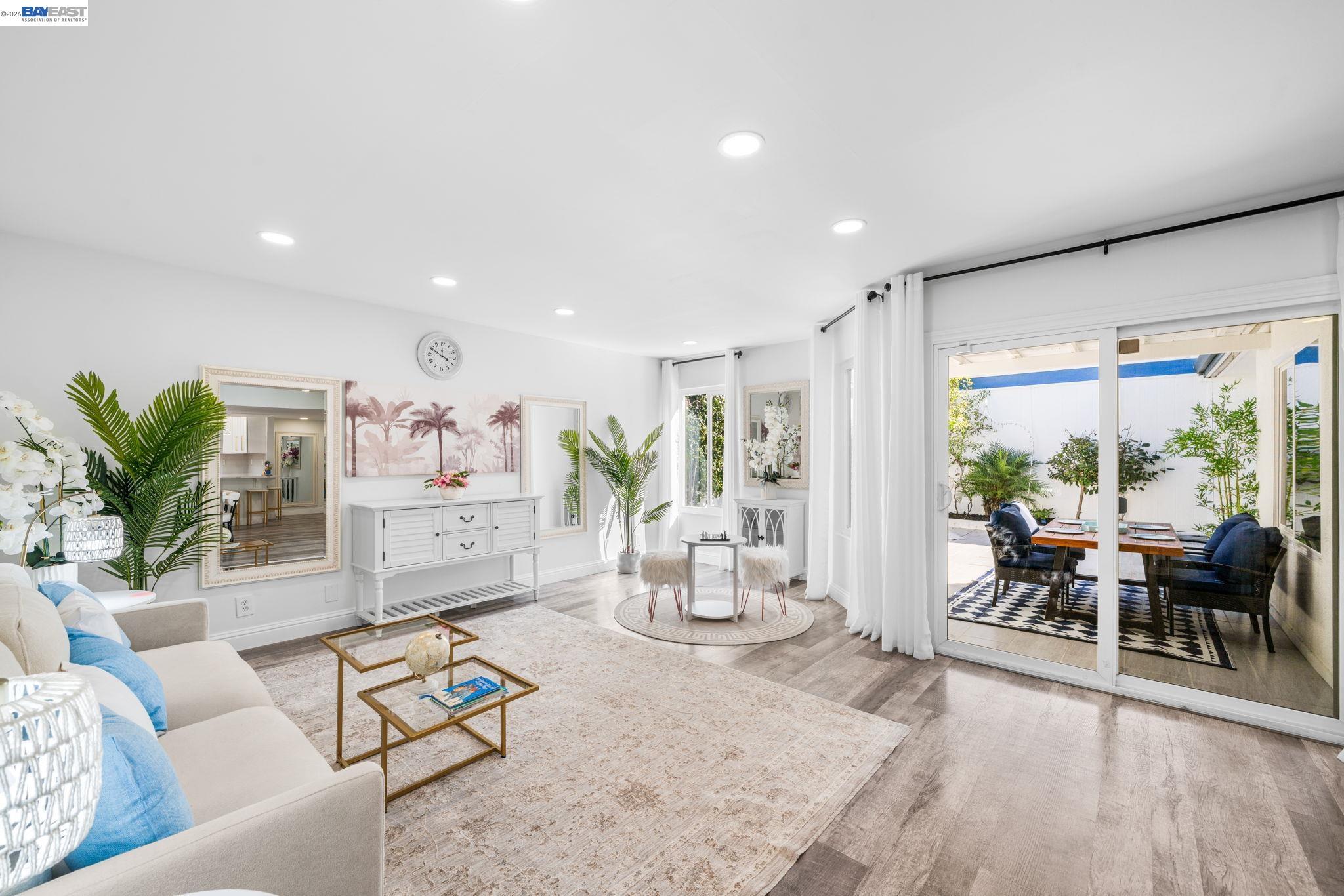 4019 Rennellwood Way Pleasanton, CA 94566 - Photo 23 of 48 a living room with furniture wooden floor dining table and a floor to ceiling window
