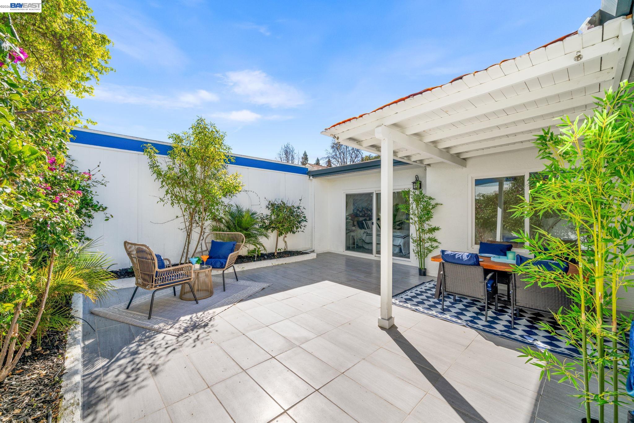 4019 Rennellwood Way Pleasanton, CA 94566 - Photo 36 of 48 a view of a patio with table and chairs potted plants and floor to ceiling window and potted plants