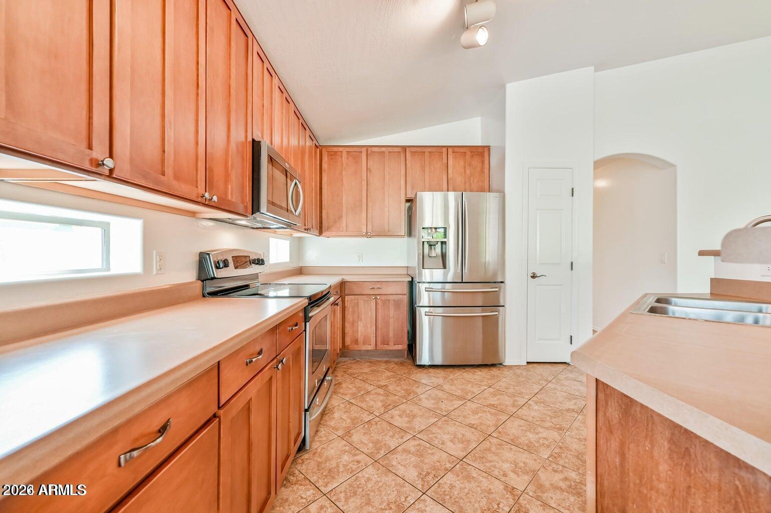 7809 South 20th Lane Phoenix, AZ 85041 - Photo 14 of 31 a kitchen with a sink refrigerator and cabinets