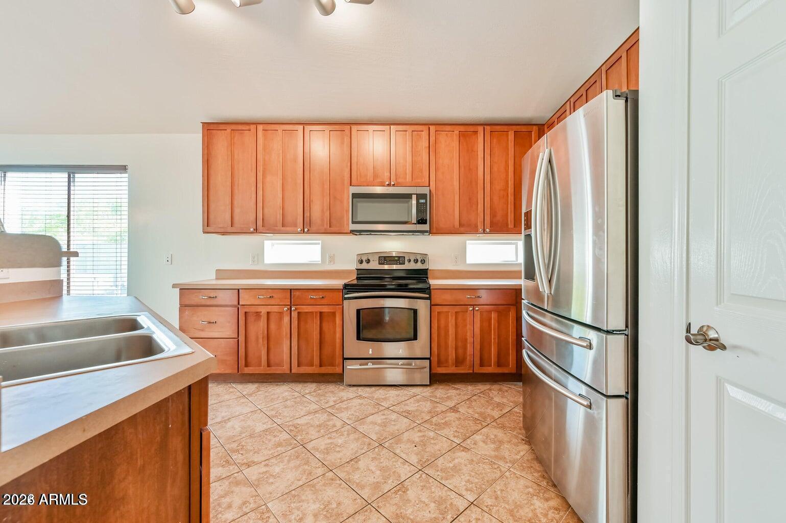 7809 South 20th Lane Phoenix, AZ 85041 - Photo 15 of 31 a kitchen with granite countertop a refrigerator stove and sink