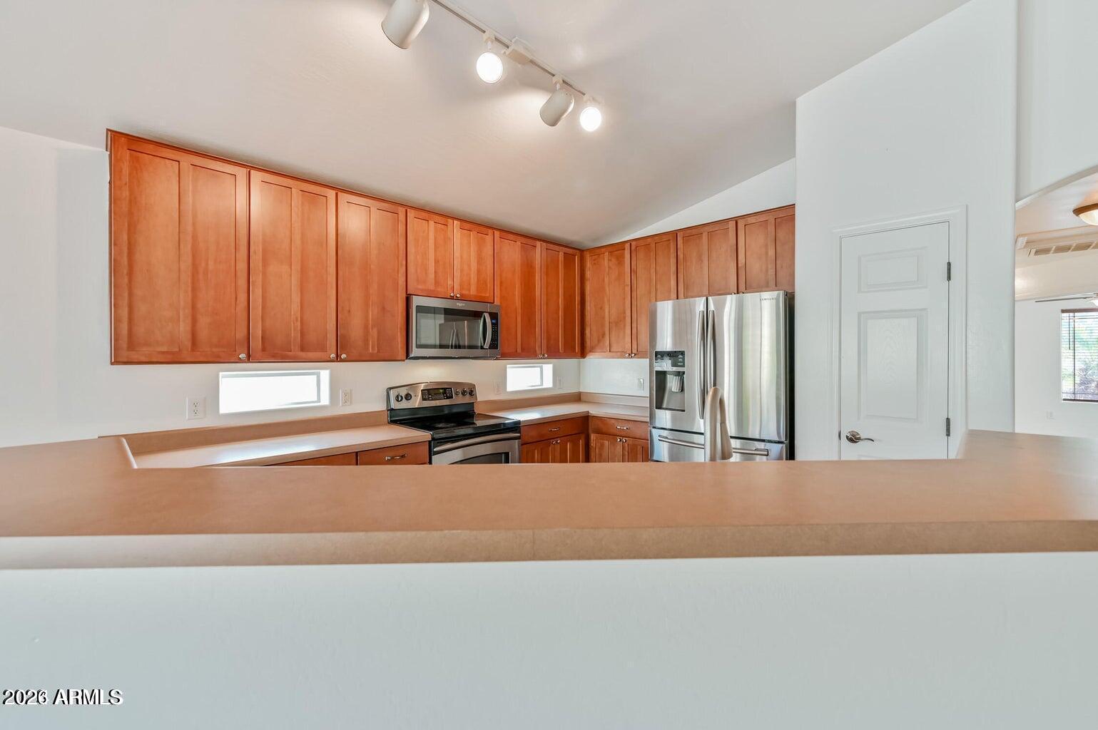 7809 South 20th Lane Phoenix, AZ 85041 - Photo 17 of 31 a kitchen with stainless steel appliances a refrigerator sink and cabinets