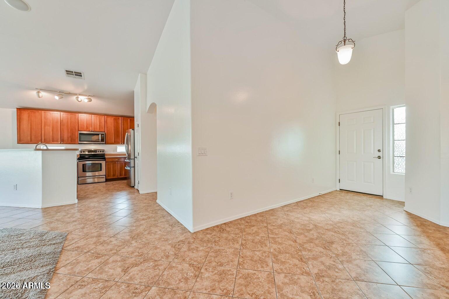 7809 South 20th Lane Phoenix, AZ 85041 - Photo 7 of 31 an empty room with kitchen view and a kitchen view