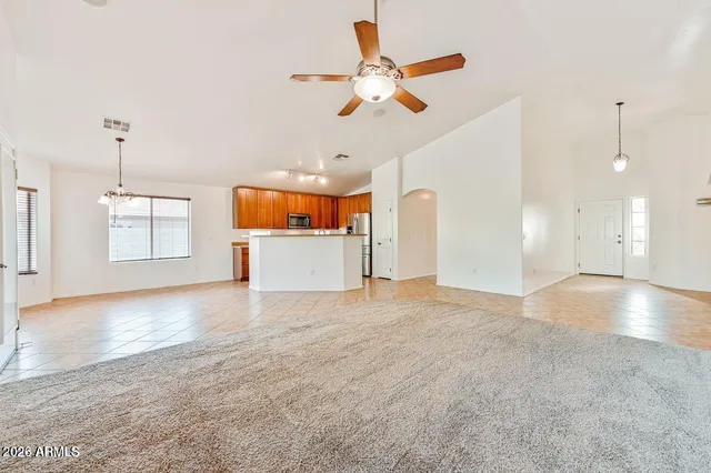 a view of empty room with wooden floor and ceiling fan