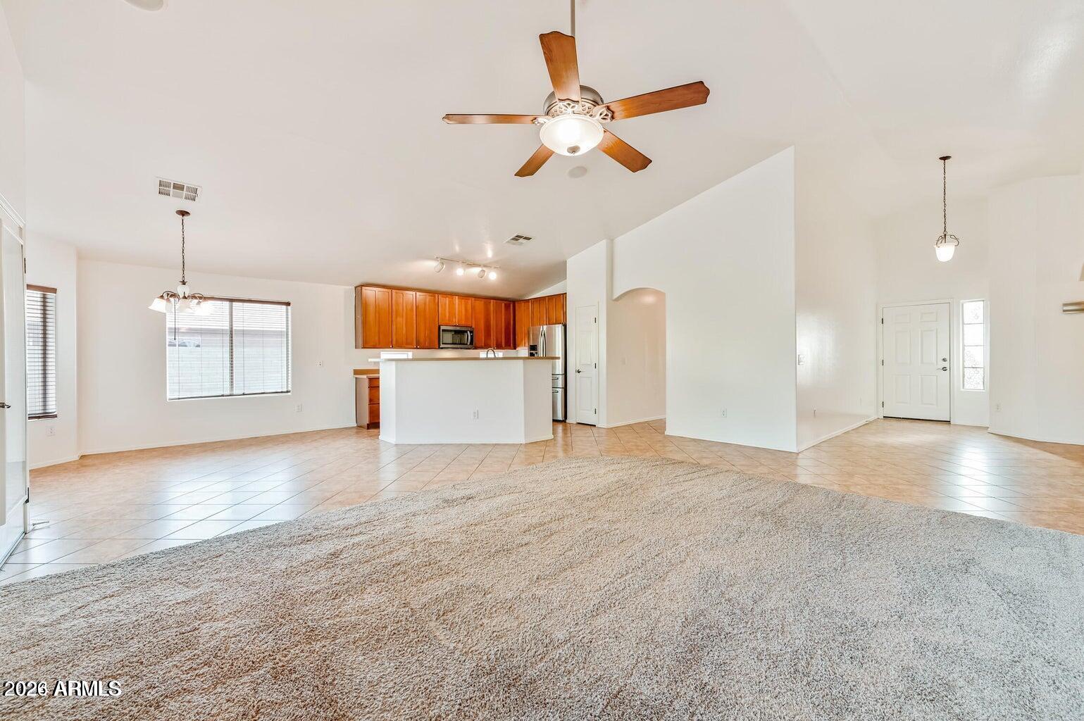 7809 South 20th Lane Phoenix, AZ 85041 - Photo 10 of 31 a view of empty room with wooden floor and ceiling fan