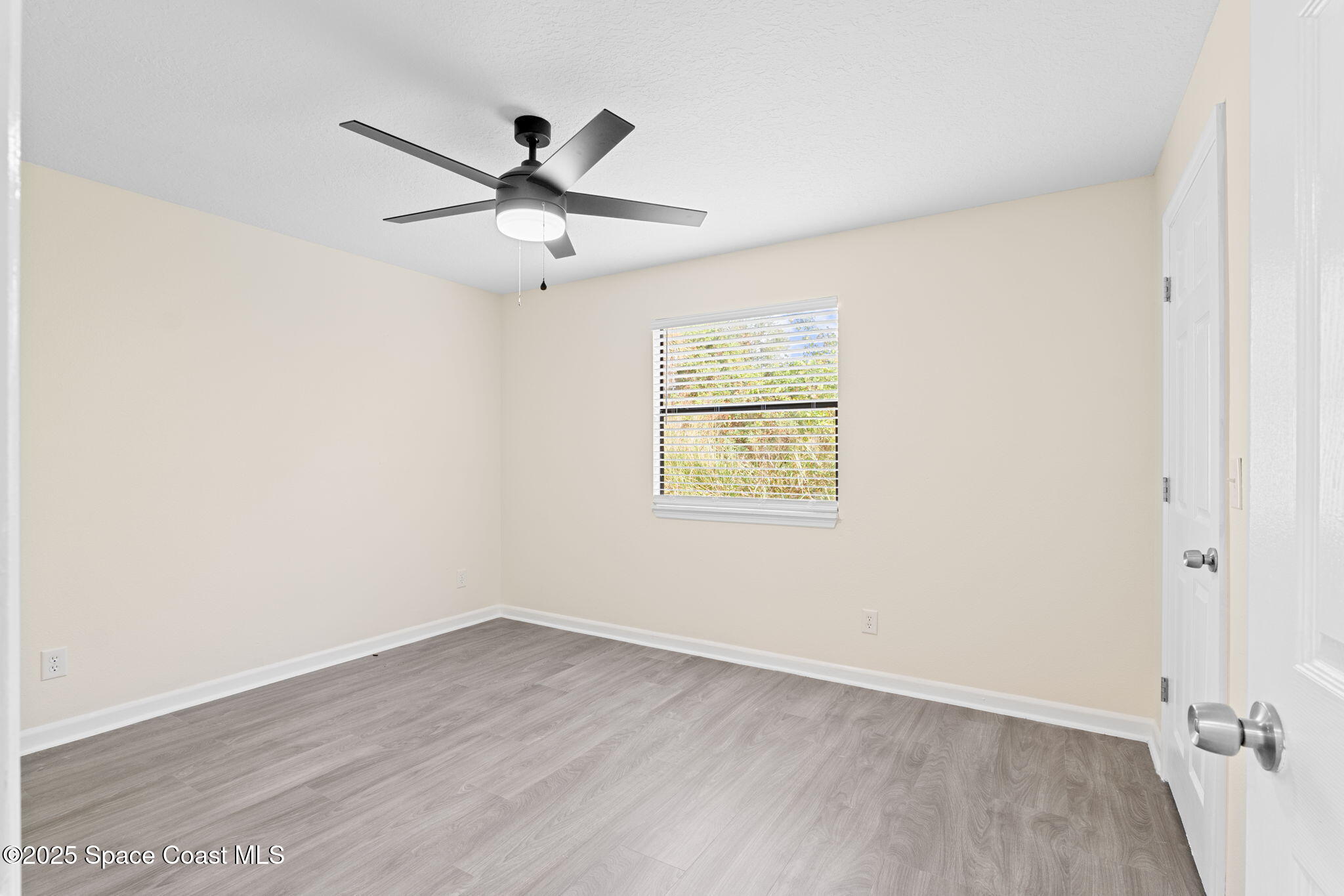 1884 Agora Circle Southeast, Unit 101 Palm Bay, FL 32909 - Photo 13 of 18 an empty room with wooden floor fan and windows