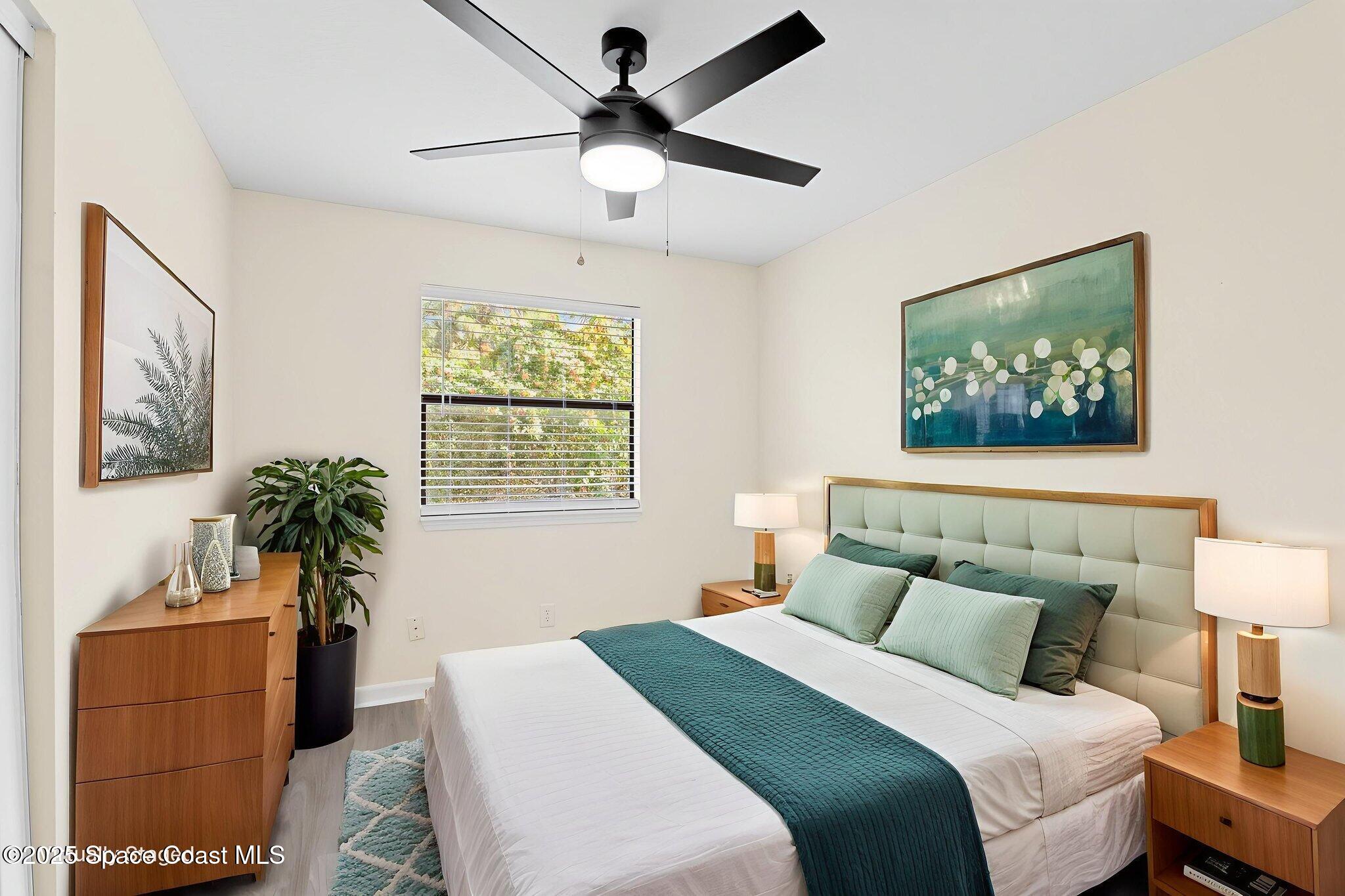 1884 Agora Circle Southeast, Unit 101 Palm Bay, FL 32909 - Photo 15 of 18 a bedroom with a large bed and a chandelier