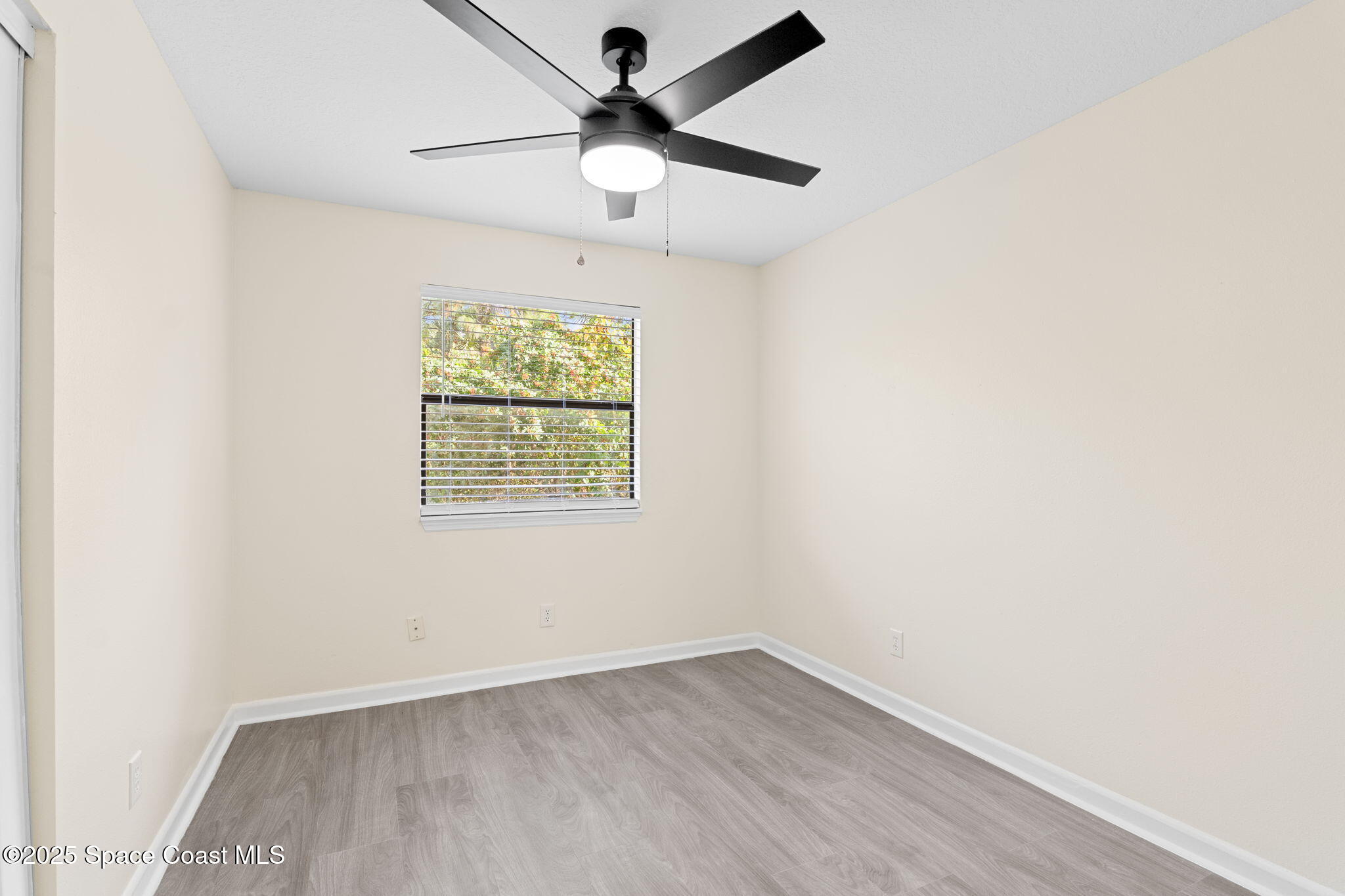 1884 Agora Circle Southeast, Unit 101 Palm Bay, FL 32909 - Photo 16 of 18 an empty room with wooden floor and windows