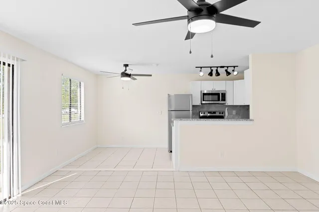 a view of kitchen with cabinets and window