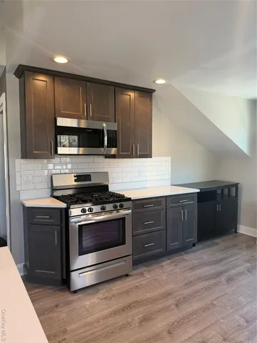 a kitchen with stainless steel appliances wooden cabinets and a stove top oven