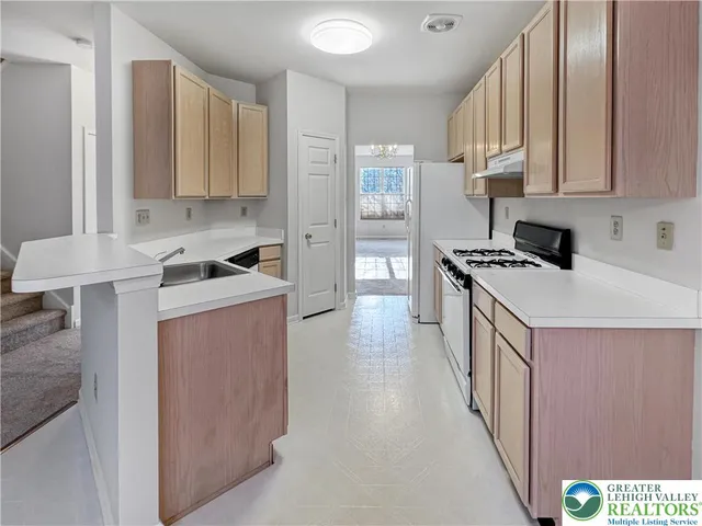 a kitchen with stainless steel appliances a stove a sink a refrigerator and cabinets