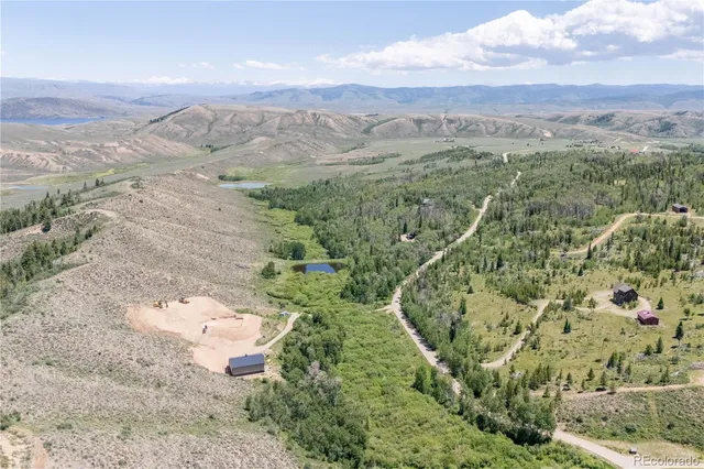 an aerial view of a house with a mountain
