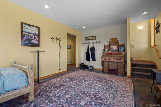 a spacious bedroom with a bed and a television