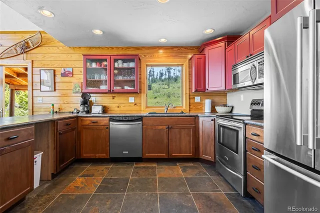 a kitchen with stainless steel appliances granite countertop a stove a sink and a refrigerator