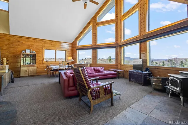 a living room with furniture a large window and a table