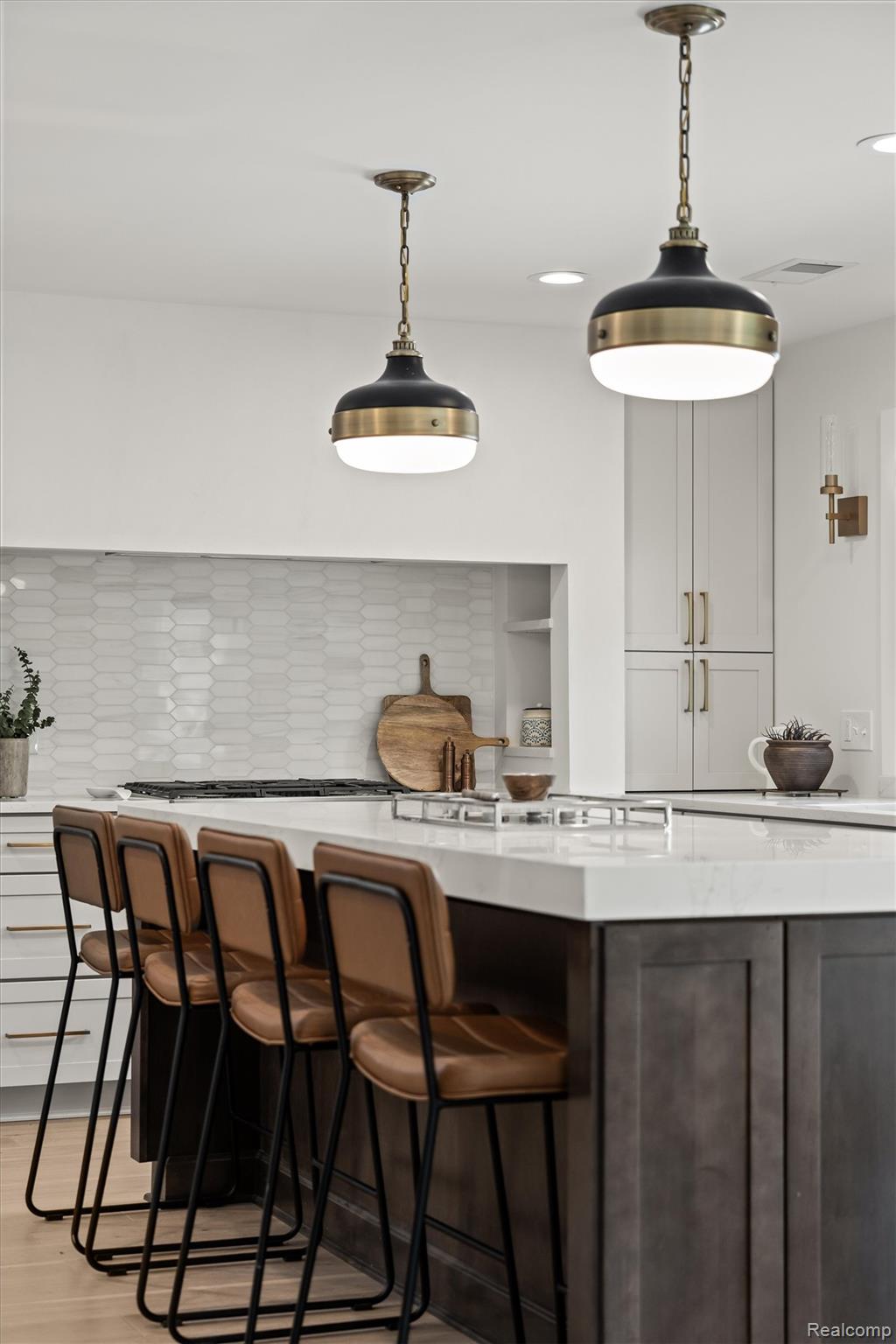 347 Highland Avenue Rochester, MI 48307 - Photo 12 of 59 Kitchen island featuring a light-toned countertop, dark wood-finish cabinetry, and built-in stovetop