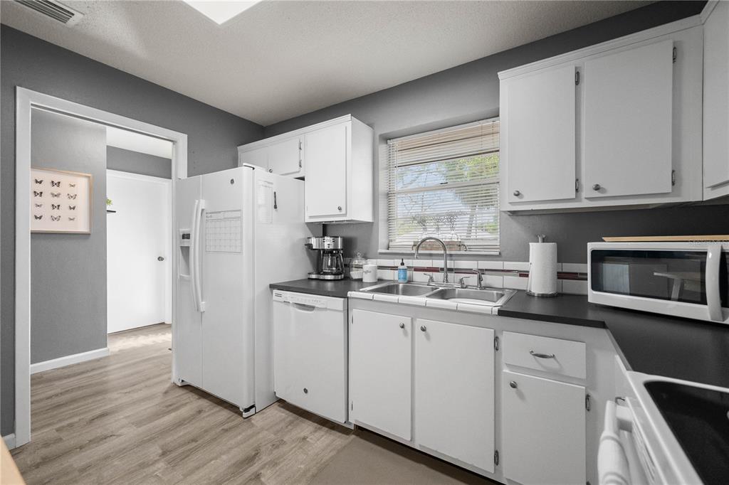 1960 Union Street, Unit 28 Clearwater, FL 33763 - Photo 7 of 23 a kitchen with granite countertop white cabinets and white appliances