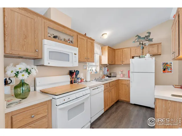 a kitchen with sink a refrigerator and white cabinets