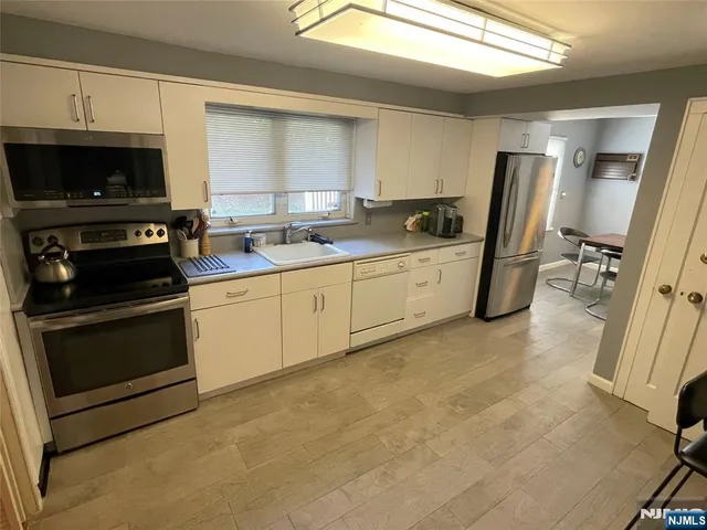 a kitchen with stainless steel appliances a stove a sink and a microwave