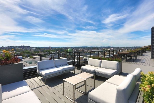 a view of roof deck with couches and wooden floor