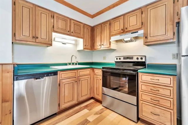 a kitchen with a refrigerator a stove top oven and cabinets