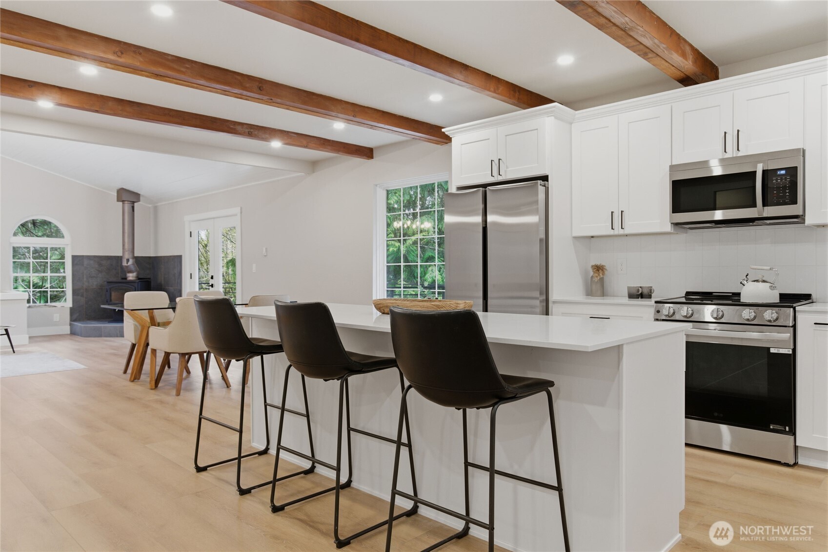 25816 178th Street Southeast Monroe, WA 98272 - Photo 8 of 40 a kitchen with stainless steel appliances kitchen island granite countertop a stove a refrigerator a sink a dining table and chairs with wooden floor