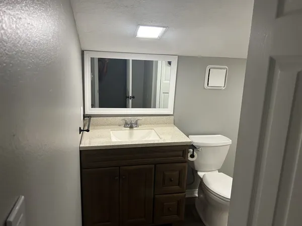 a bathroom with a toilet sink and mirror
