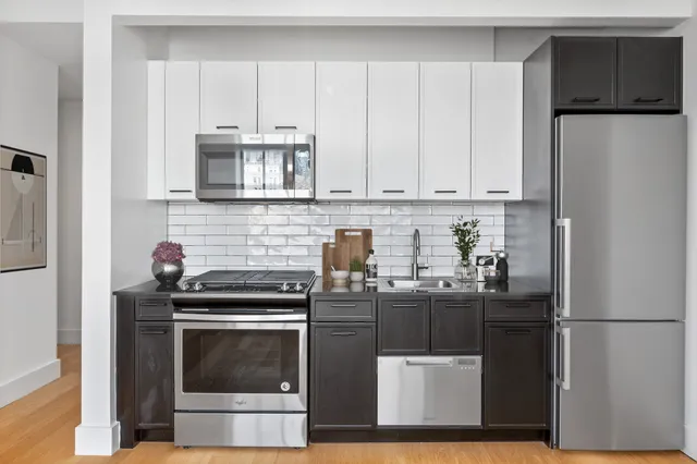 a kitchen with stainless steel appliances a stove a refrigerator a sink and cabinets