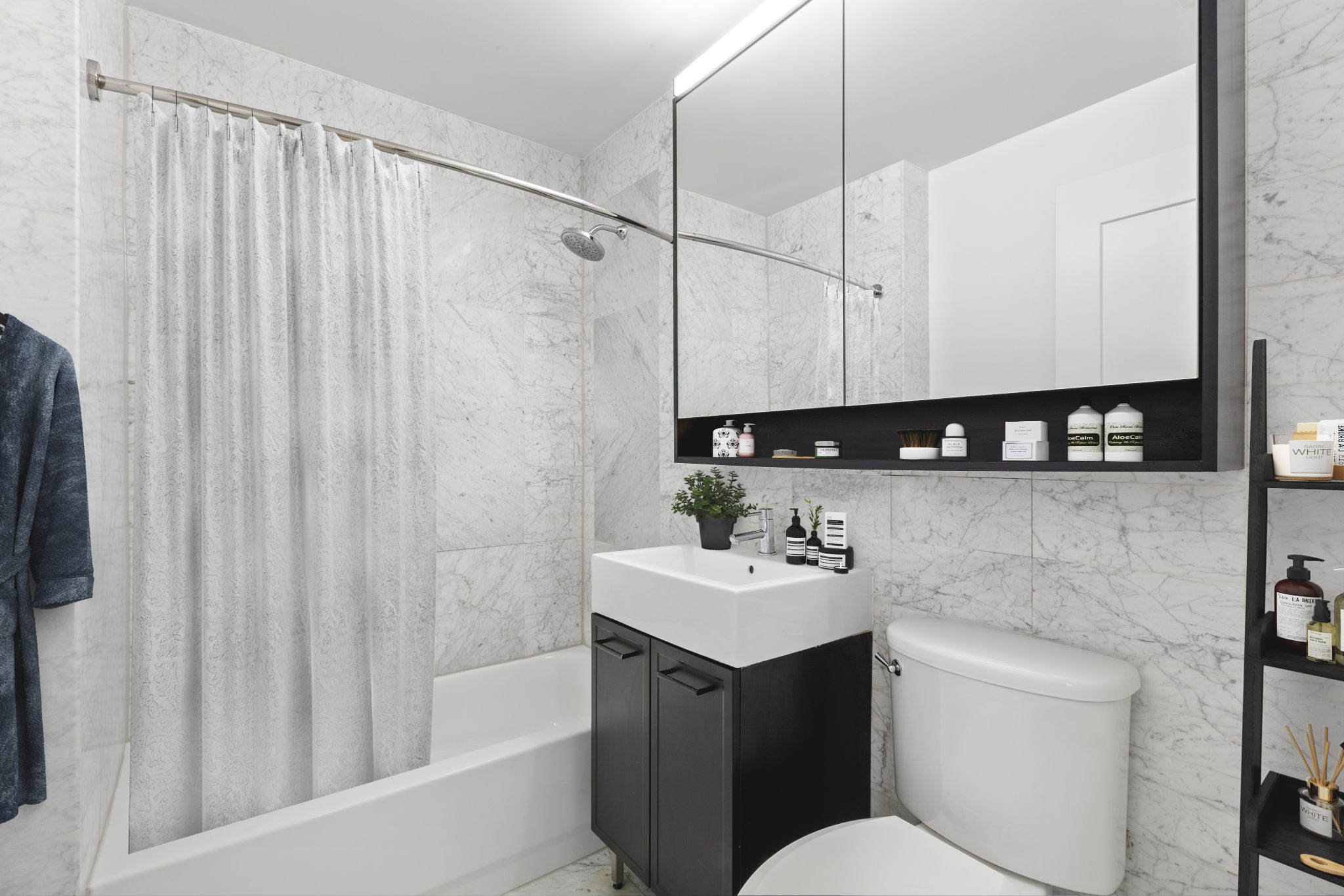 63 Wall Street, Unit 405 Manhattan, NY 10005 - Photo 7 of 20 a bathroom with a sink a toilet and shower
