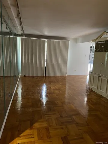 a view of empty room with wooden floor