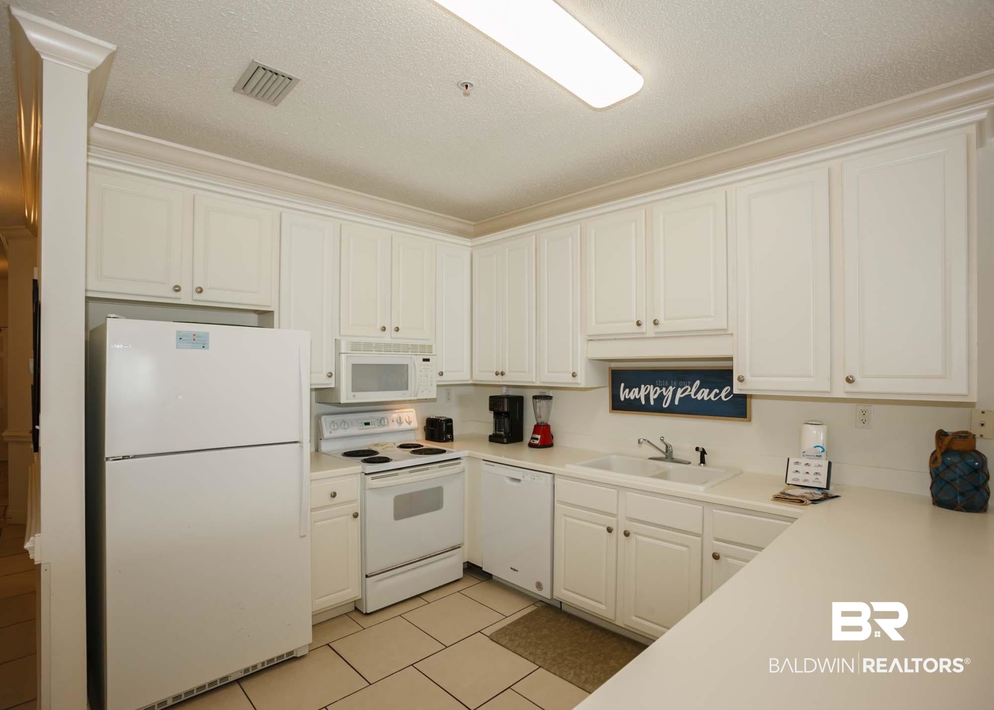 28910 Perdido Beach Boulevard, Unit 4B Orange Beach, AL 36561 - Photo 7 of 48 Kitchen featuring a textured ceiling, visible vents, white appliances, a sink, and light tile patterned floors