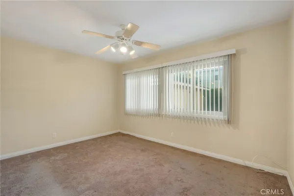 an empty room with a window and a fan