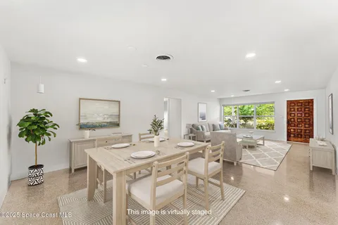 a living room with furniture potted plant and a large window