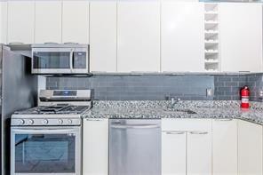 210 Walker Street Southwest, Unit 1 Atlanta, GA 30313 - Photo 20 of 37 a kitchen with stainless steel appliances granite countertop a stove a sink and a microwave