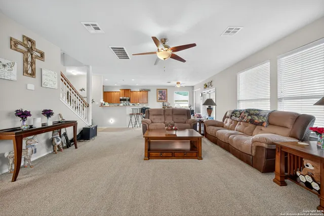 a living room with furniture ceiling fan and a rug