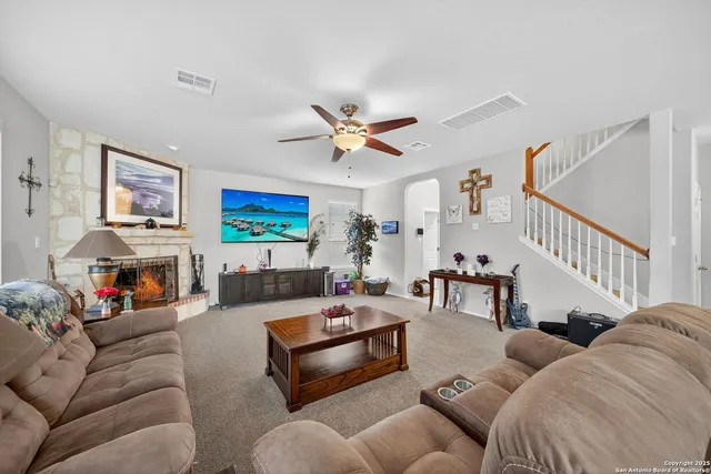 a kitchen with stainless steel appliances granite countertop a stove top oven a refrigerator a sink and a chairs